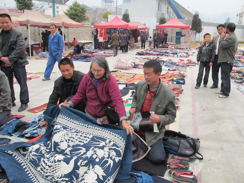 Pamela looking at a Chinese rug in a market